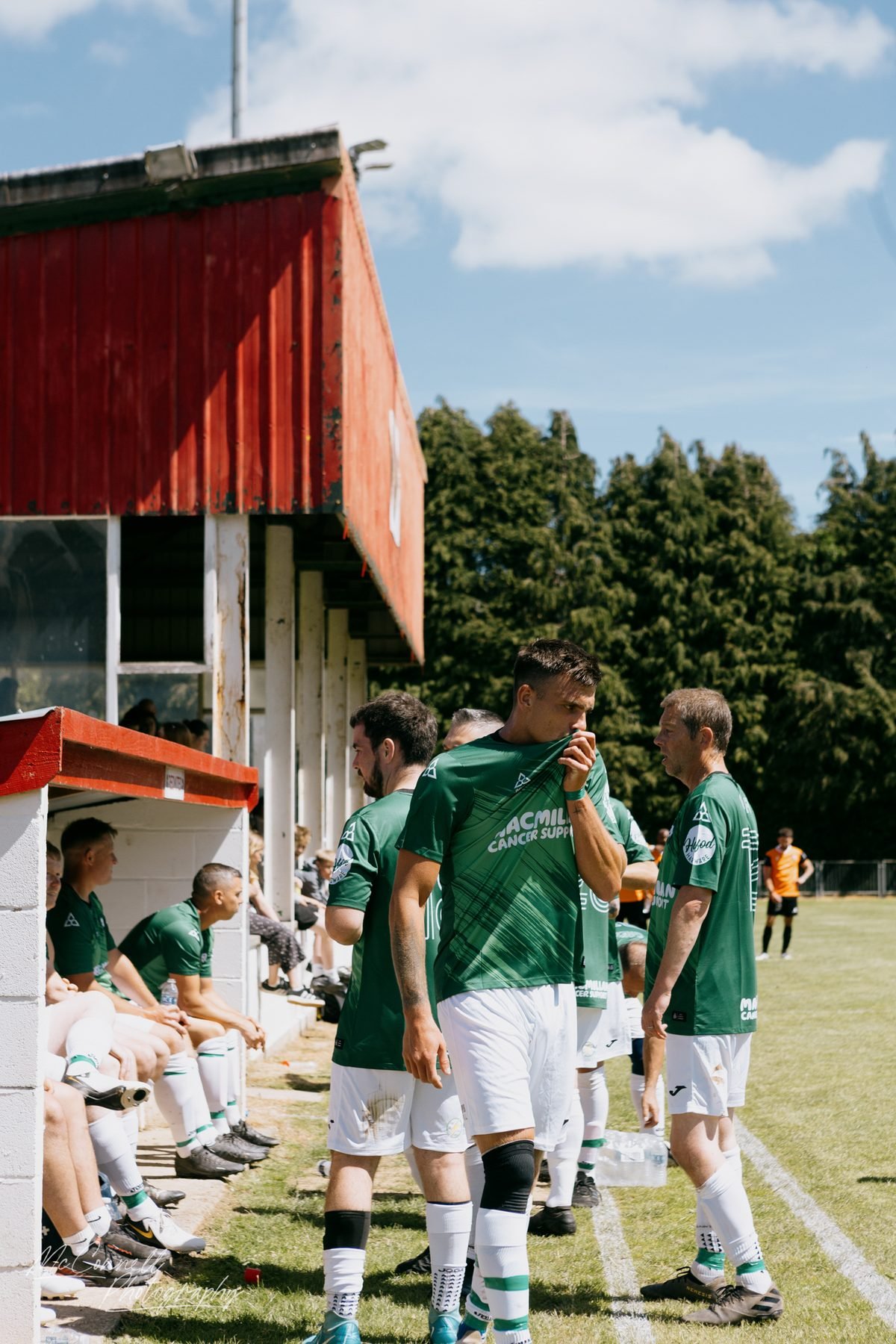Substitutes and staff gathered by the dugout at half time